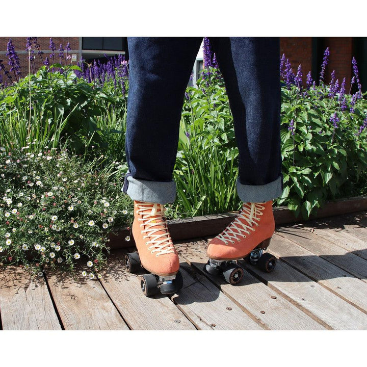 Chuffed Skates peach pink roller skates on boardwalk with lavender flowers behind