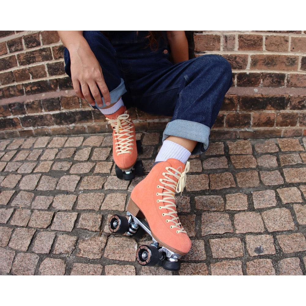 Chuffed Skates peach pink roller skates on brick floor