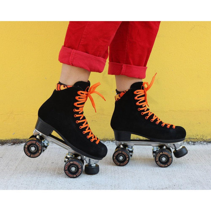 Chuffed Skates black roller skates with yellow wall behind 