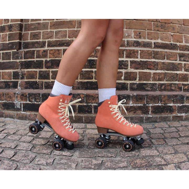 Chuffed Skates peach pink roller skates with brick background